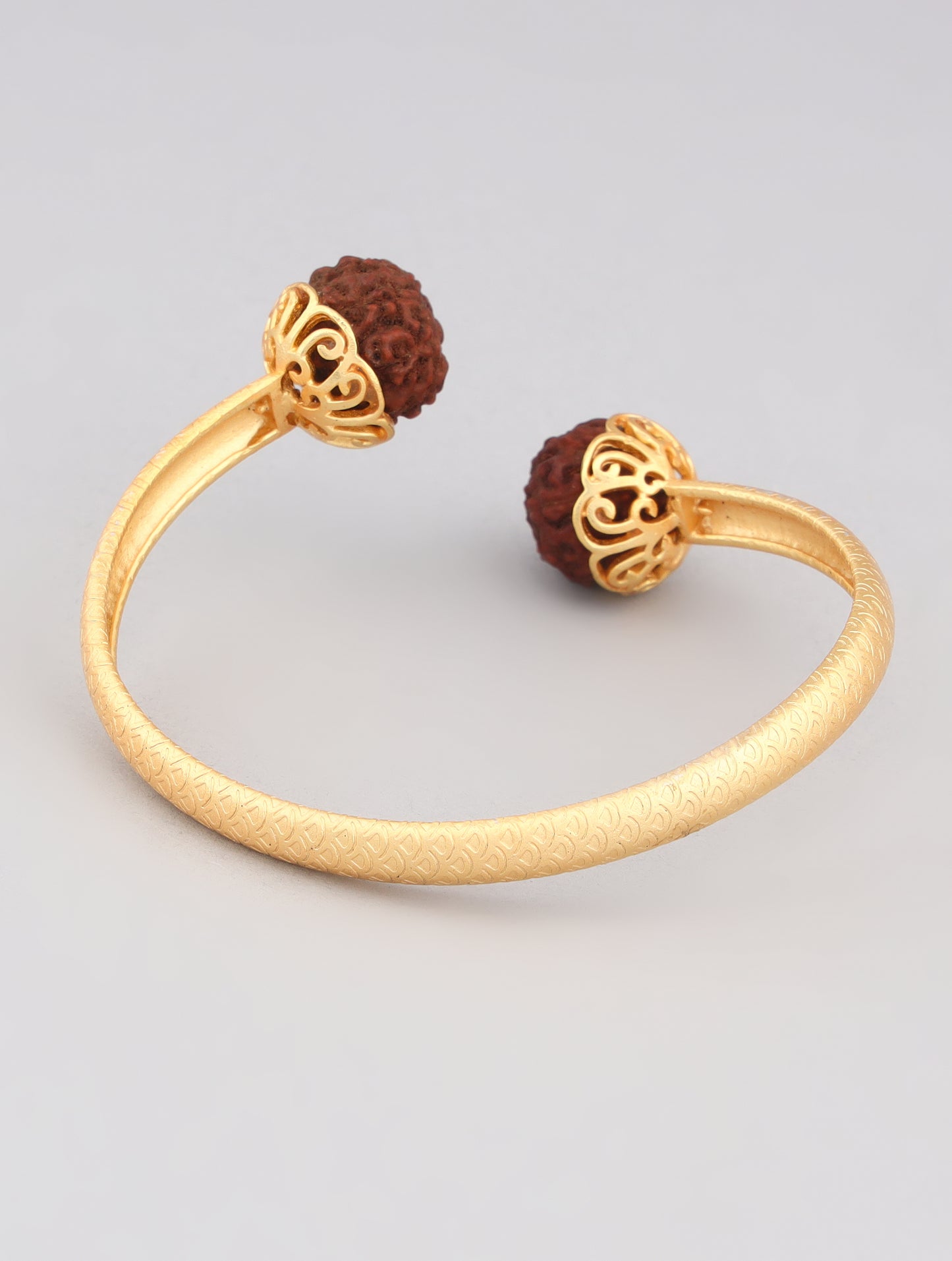 Close-up of gold-toned kada with Rudraksha beads