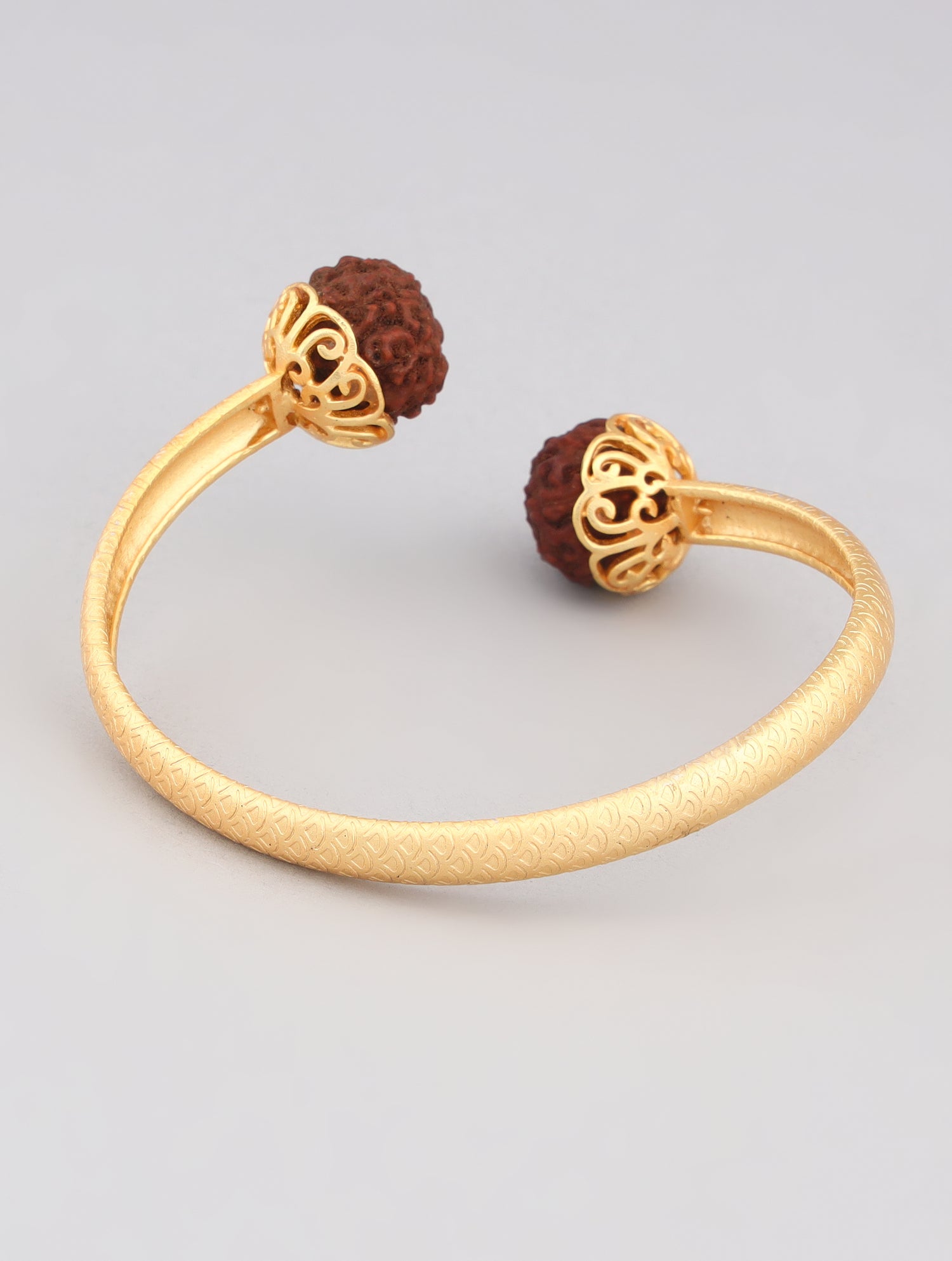 Close-up of gold-toned kada with Rudraksha beads