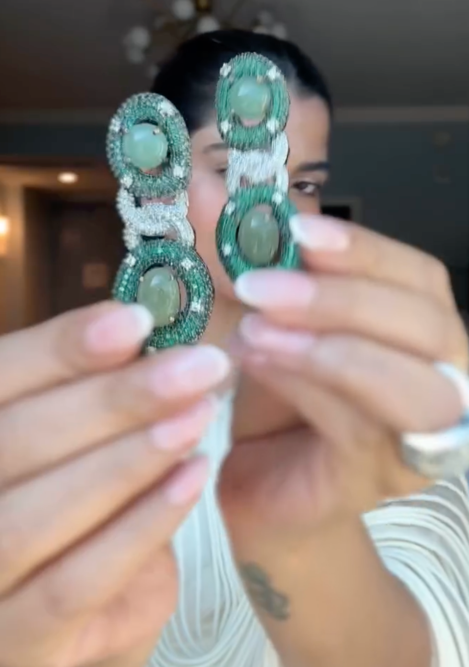 Close-up of silver Modarta chain earrings on model
