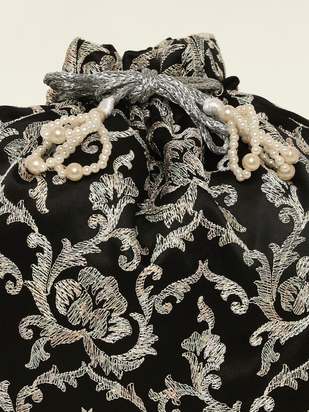 Close-up of silver embroidery on black festive potli