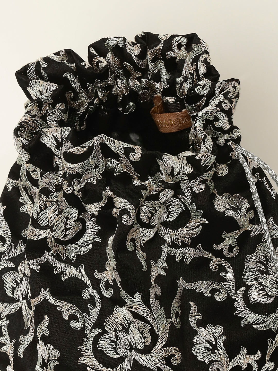 Black and silver embroidered potli displayed for weddings