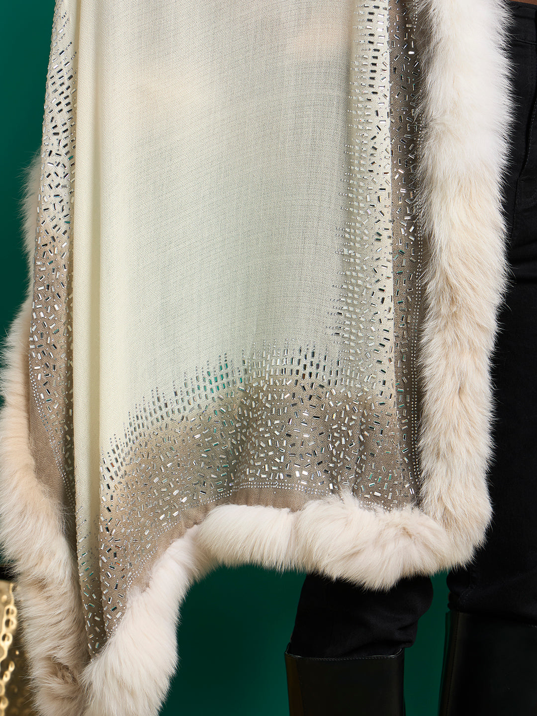 Close-up of ivory shawl edge with silver bugle-style studs fading into the weave and thick faux fur trim