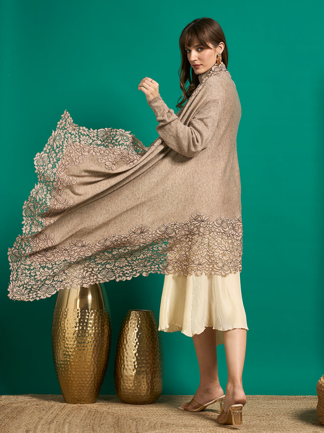 Back view of taupe lace cape with one side spread out, showing the gathered sleeve and scalloped lace border