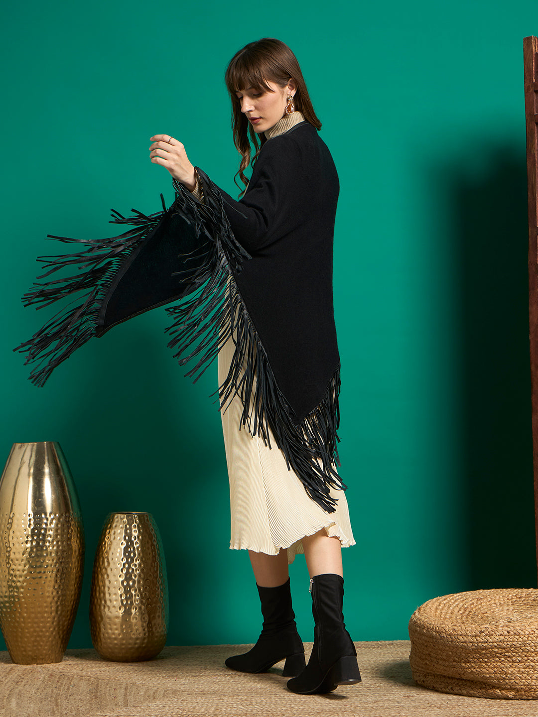 Back view of black shawl with pointed hem and long black fringe in motion