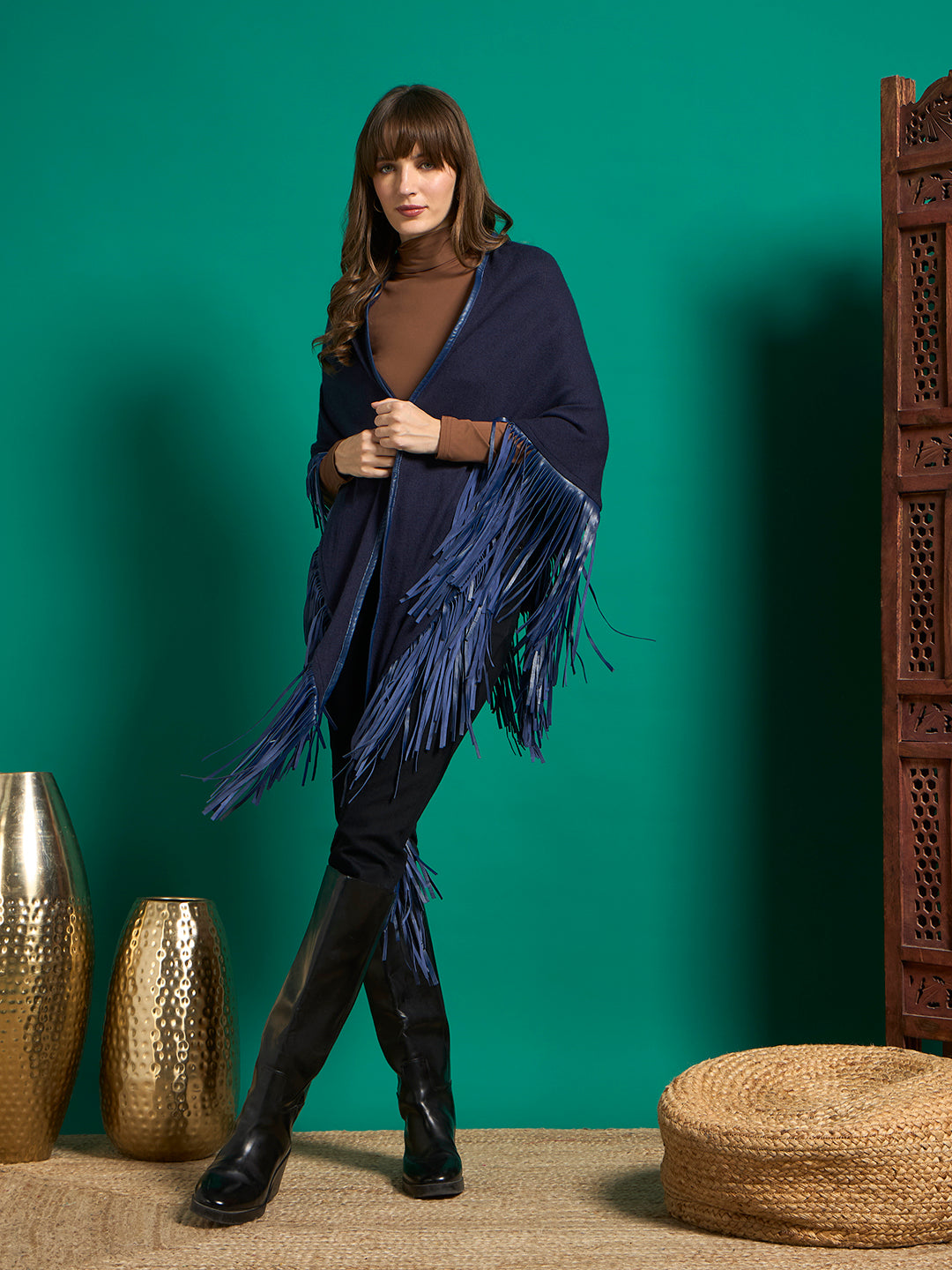 Model in navy shawl with royal blue fringe trim, worn open over brown turtleneck, black jeans and knee-high boots