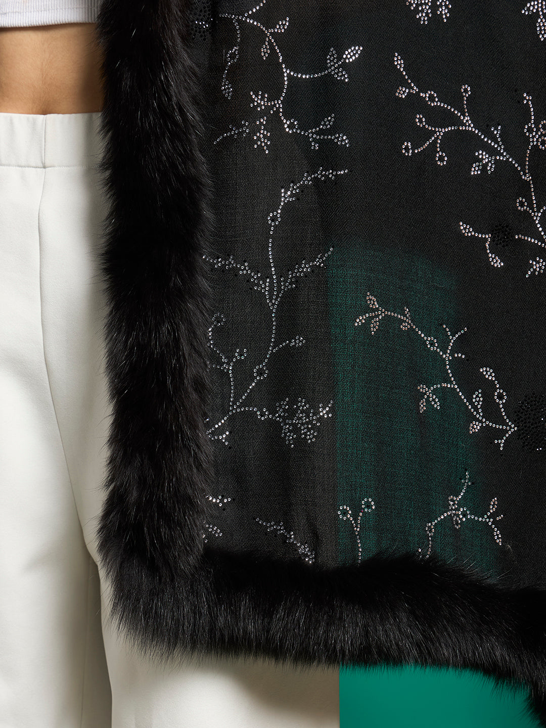 Detail of black shawl corner with faux fur trim and sparkling crystal-studded vine motifs