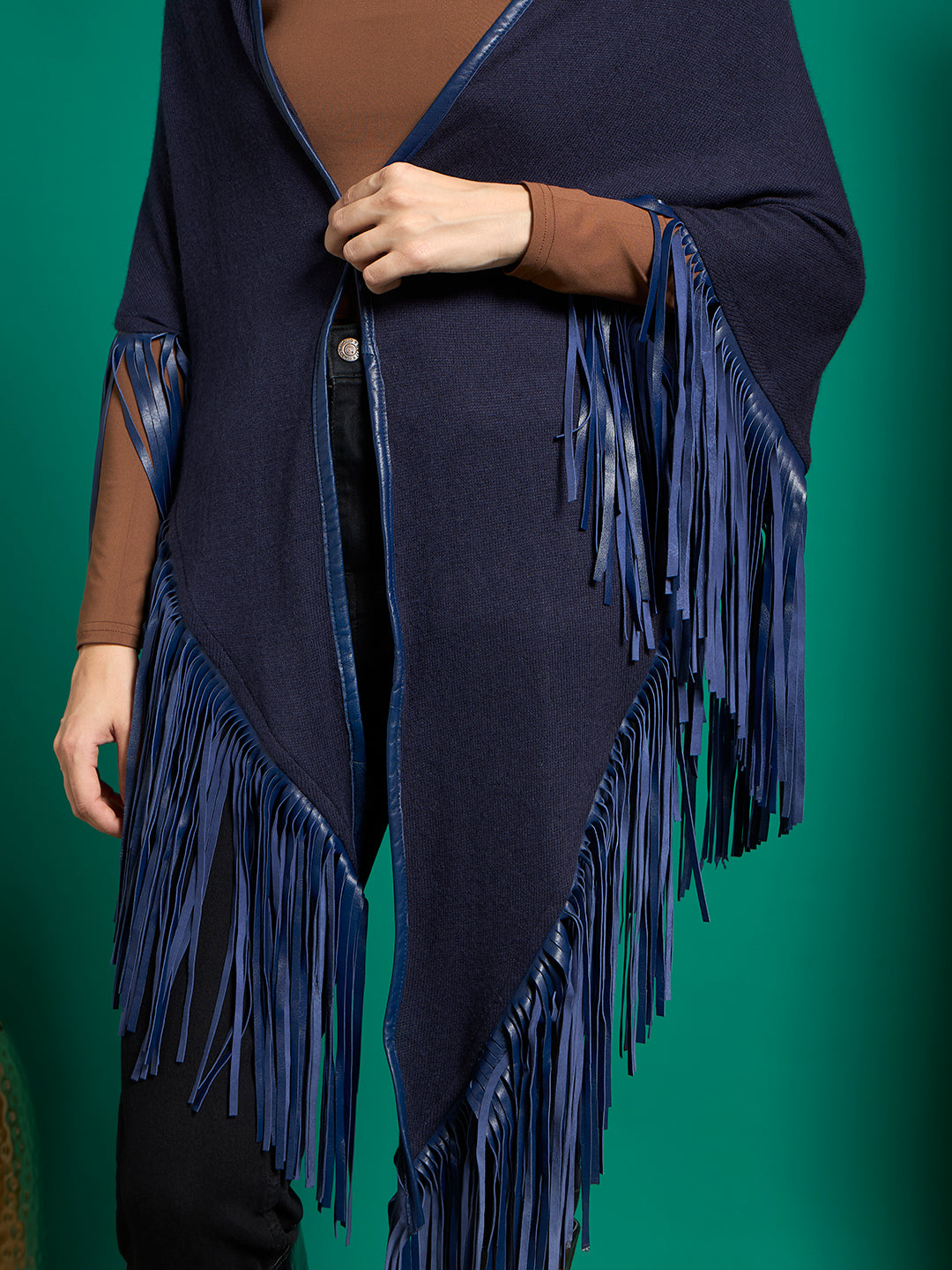 Close-up of navy knit shawl with glossy royal blue piped edges and long flat strip fringe