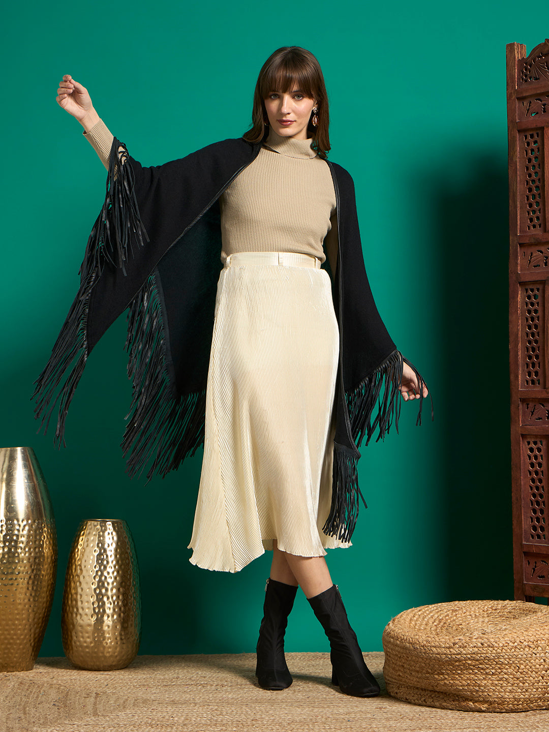 Model holding arms out to show draped black knit shawl with long black fringe edges