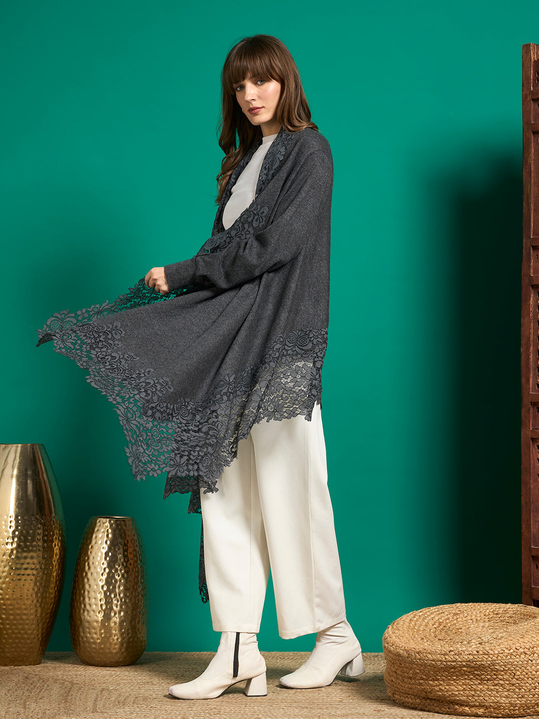 Side view of grey lace-trimmed cape with one panel held out to show the scalloped floral lace hem