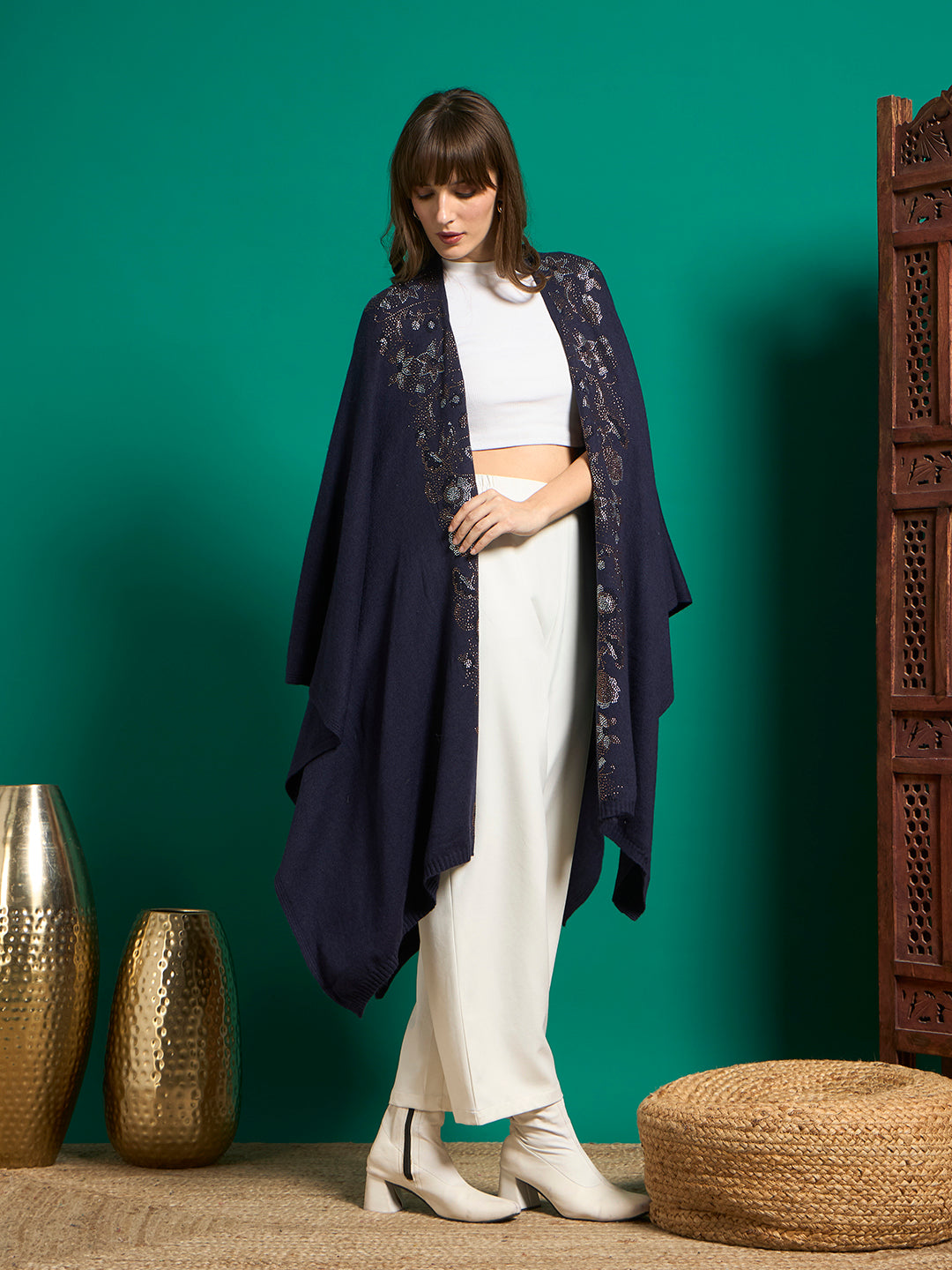 Navy open-front cape with crystal-style floral detailing along both front edges, worn open over white outfit