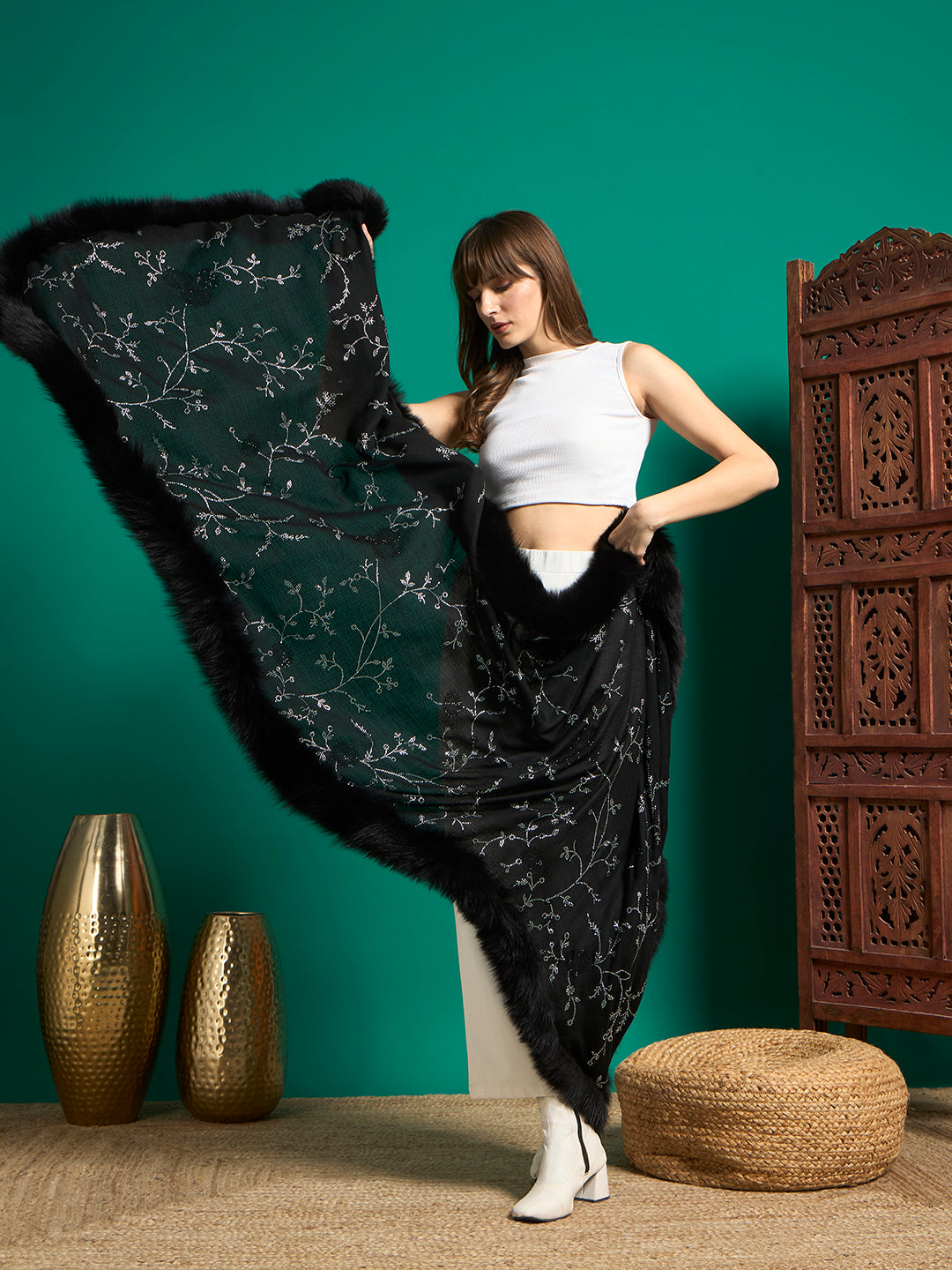 Model spreading black shawl wide to show allover crystal vine pattern and faux fur border