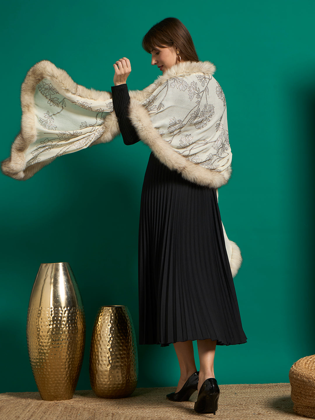 Back view of model swinging ivory faux fur-trimmed shawl with stud-embellished floral vine design
