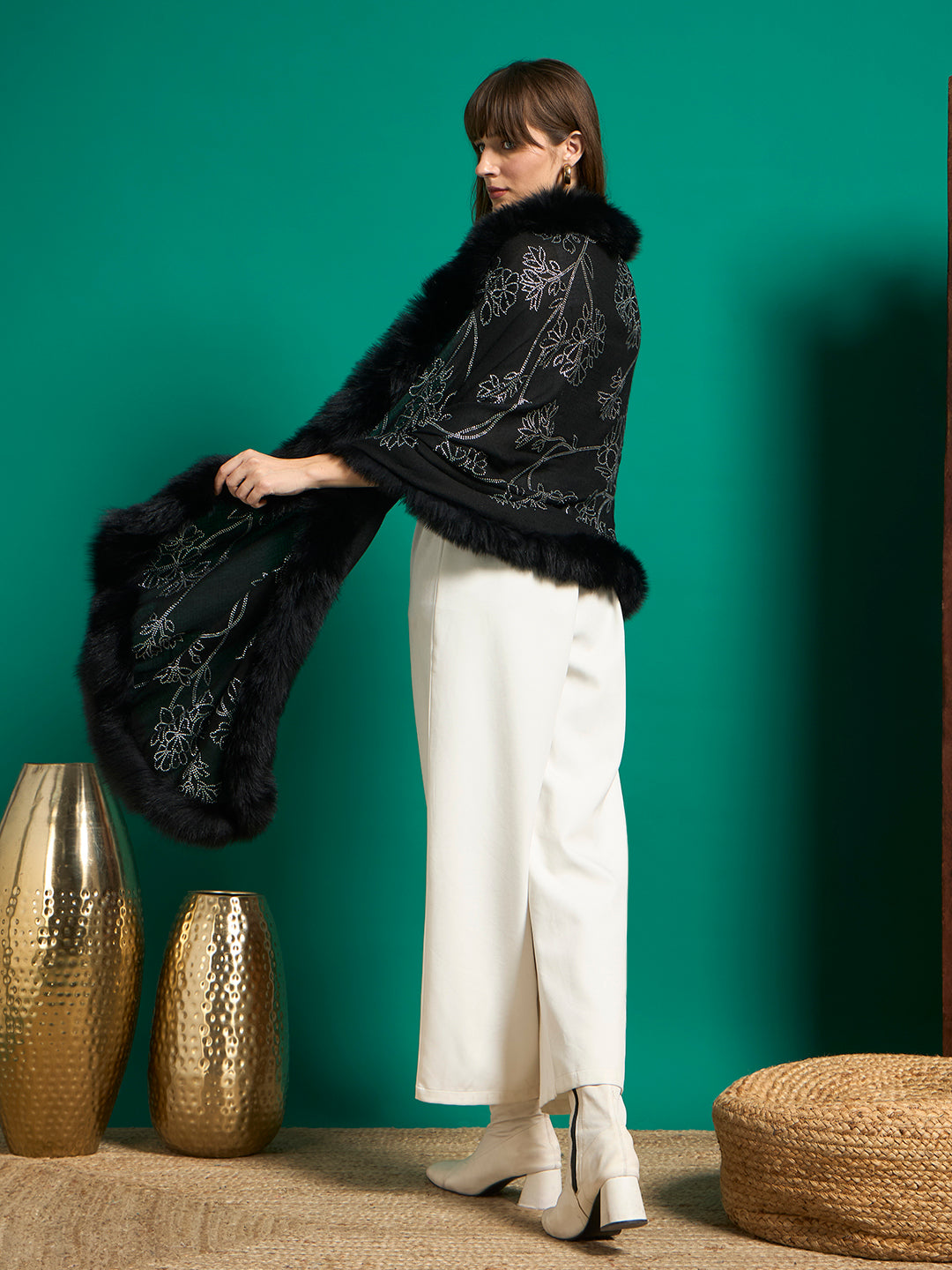 Back view of black faux fur-trimmed shawl draped like a cape, showing silver floral stud work