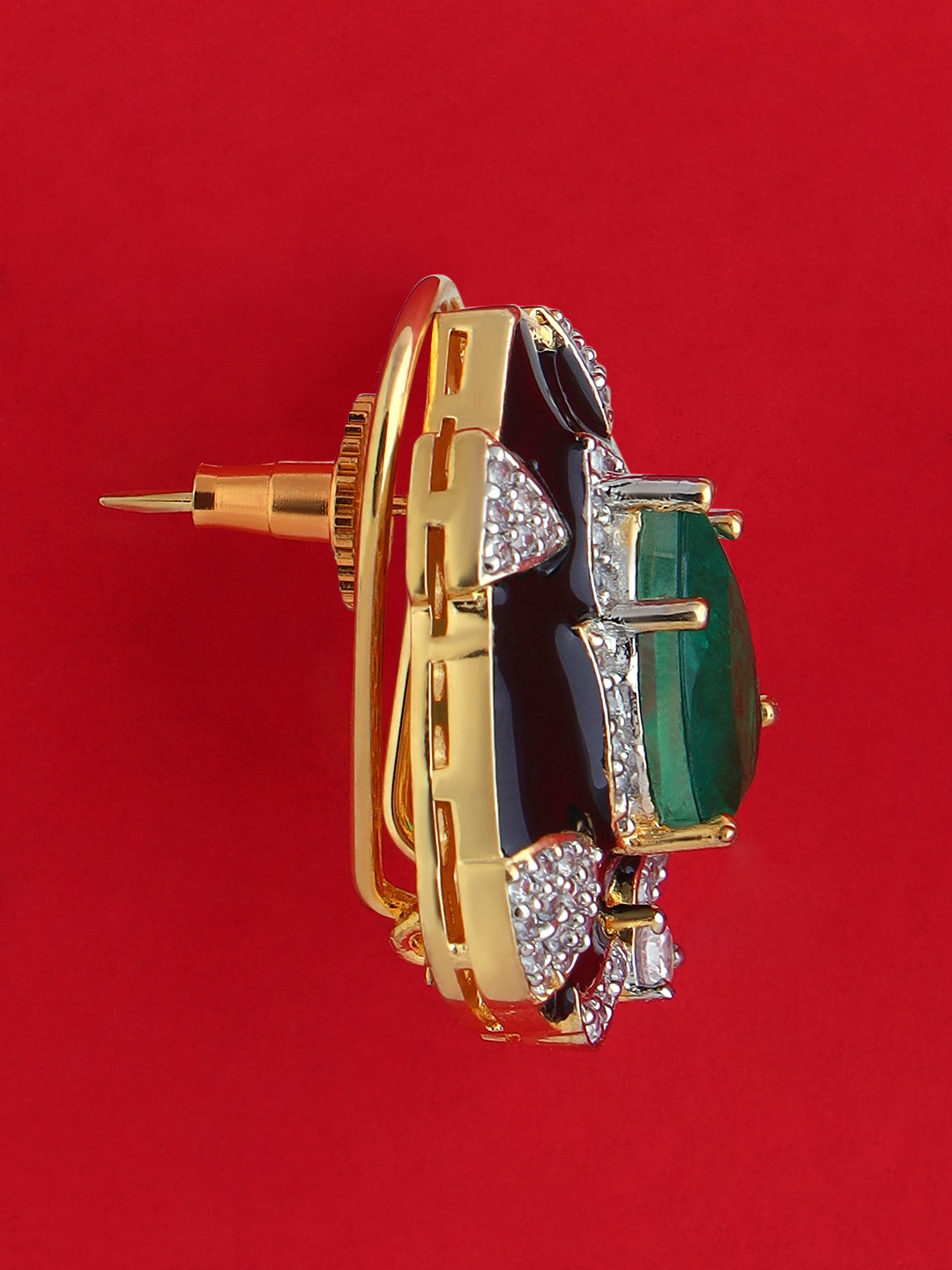 Close-up of geometric brass stud earrings set with black and emerald-green stones