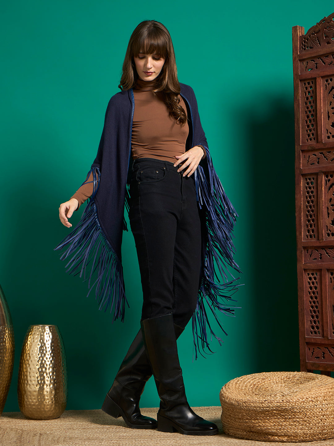 Navy fringe shawl draped open over shoulders, blue fringe falling along the arms, styled with black jeans
