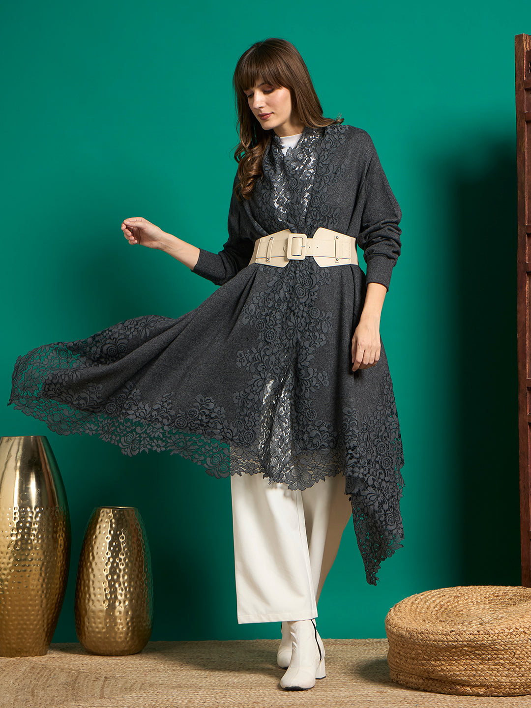Charcoal grey lace cape styled with a cream belt, its floral lace hem flared out